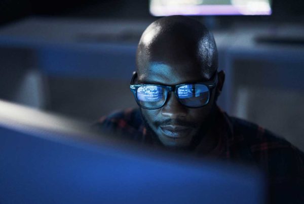 Développeur travaillant la nuit, reflet d’écran dans ses lunettes