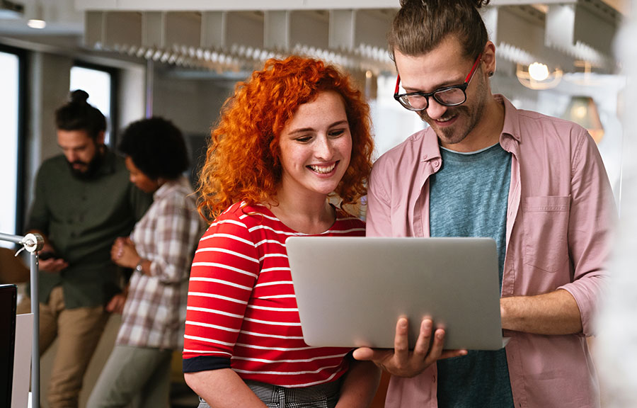 Deux personnes discutent devant un ordinateur portable en réunion